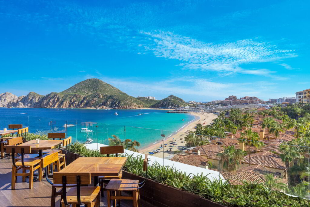 View from a restaurant in Cabo Mexico with the beach and mountains in the background.