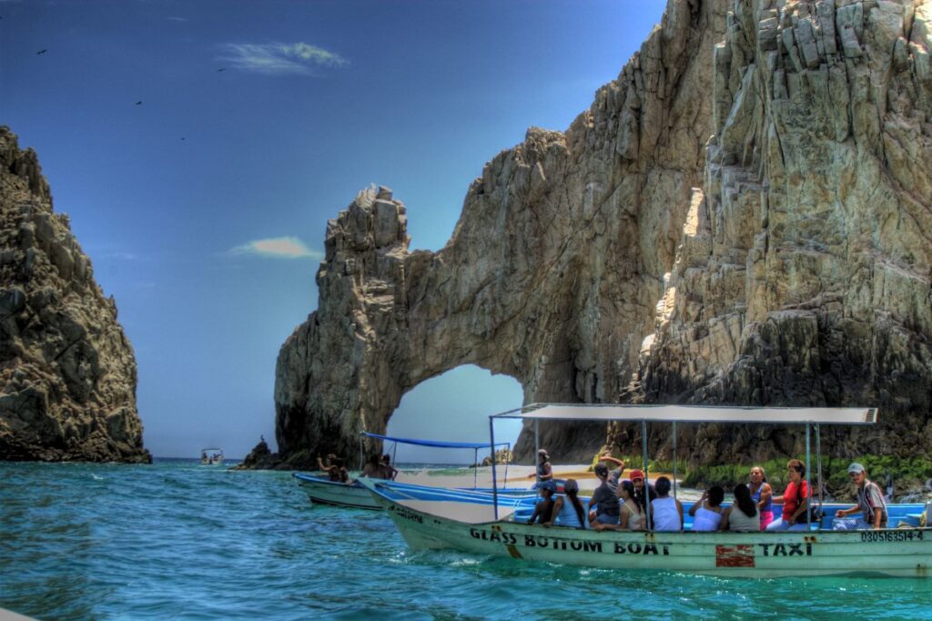 A glass bottom boat tour in front of the famous arch at Los Cabos, Mexico