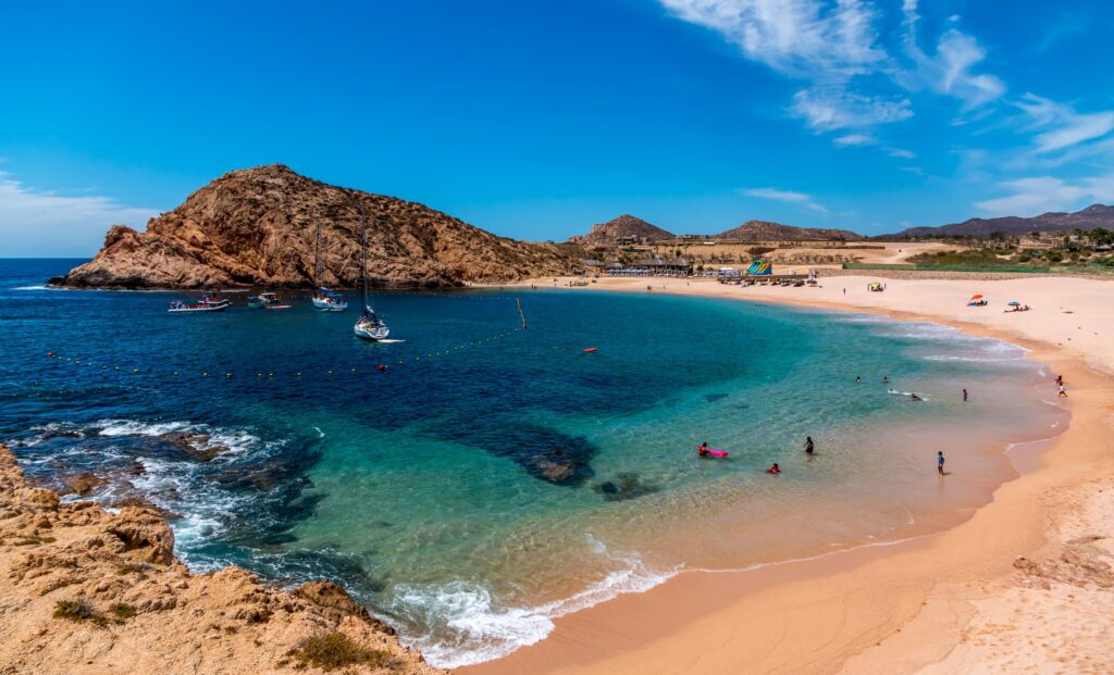 Santa Maria beach in Cabo on a sunny day. Clear blue waters and yellow sand beach.