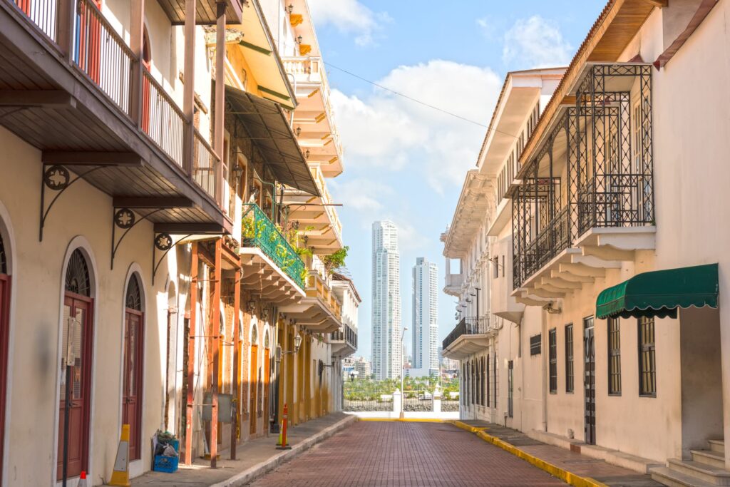 view of old fashioned streets in Casco Viejo, Panama. Modern high-rise buildings can be seen in the background.