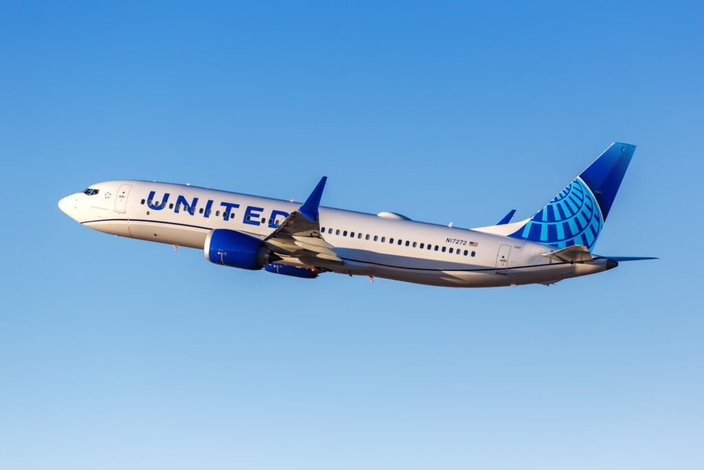 United Airlines airplane flying through a clear blue sky